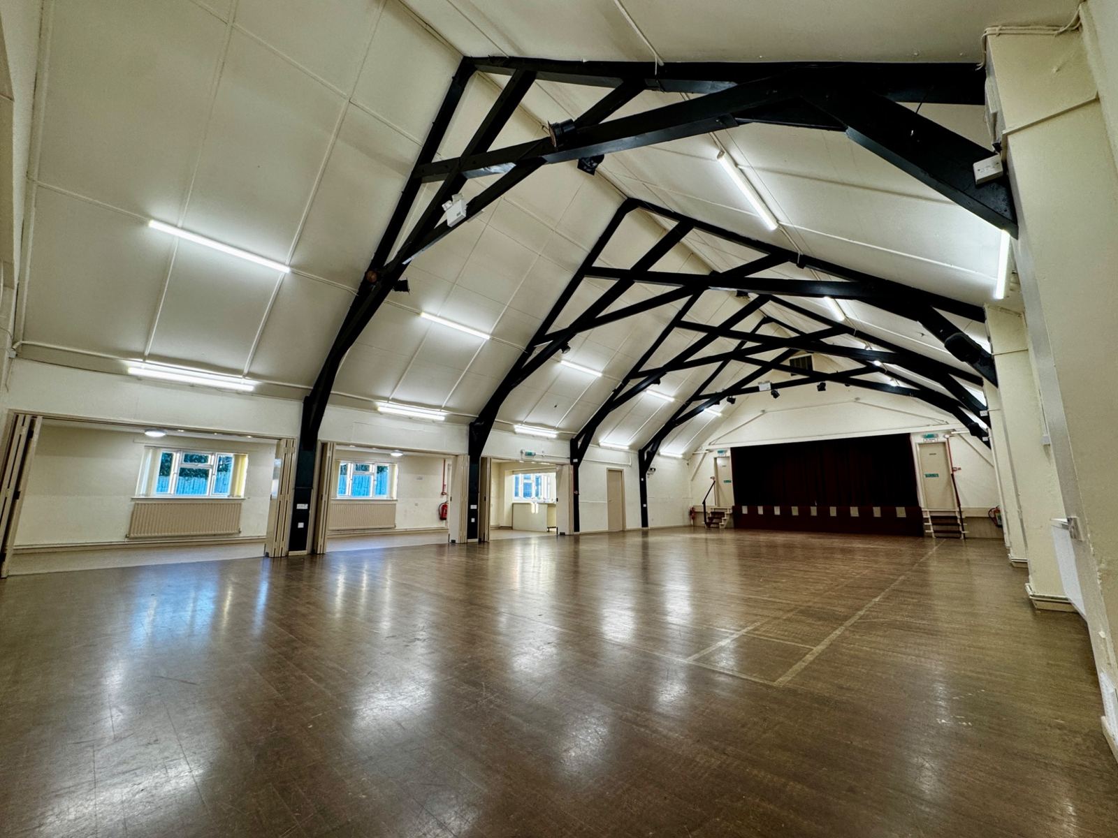 The main hall at Whitmore Village Hall, with its high beamed ceiling and wooden floor